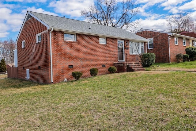 view of front facade with a front lawn, brick siding, and roof with shingles