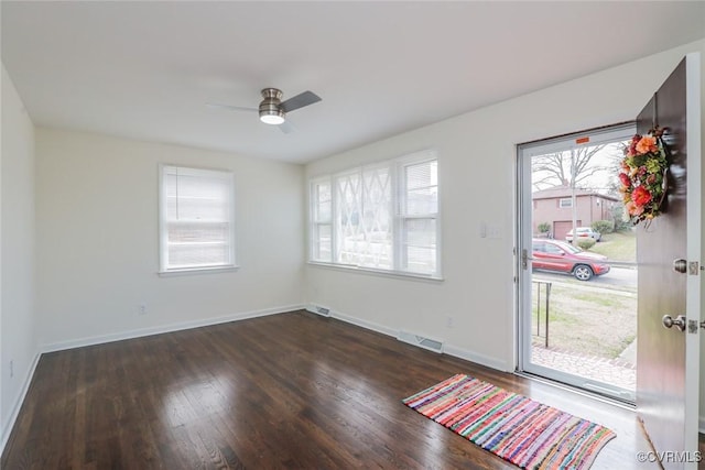 interior space with wood finished floors, a ceiling fan, visible vents, and baseboards