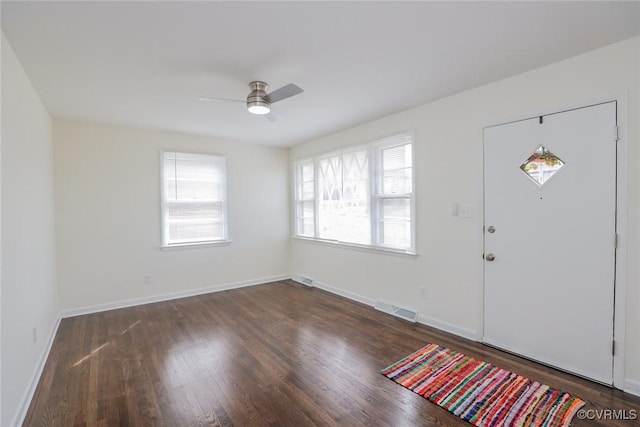 foyer entrance featuring dark wood-type flooring, baseboards, visible vents, and ceiling fan