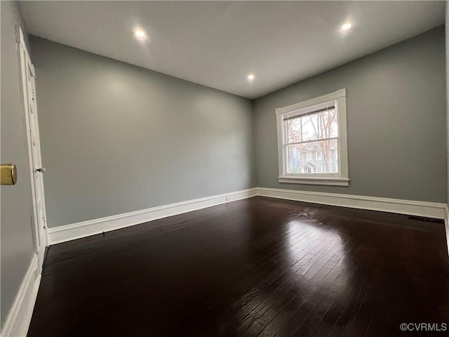 spare room with recessed lighting, baseboards, and dark wood-style flooring