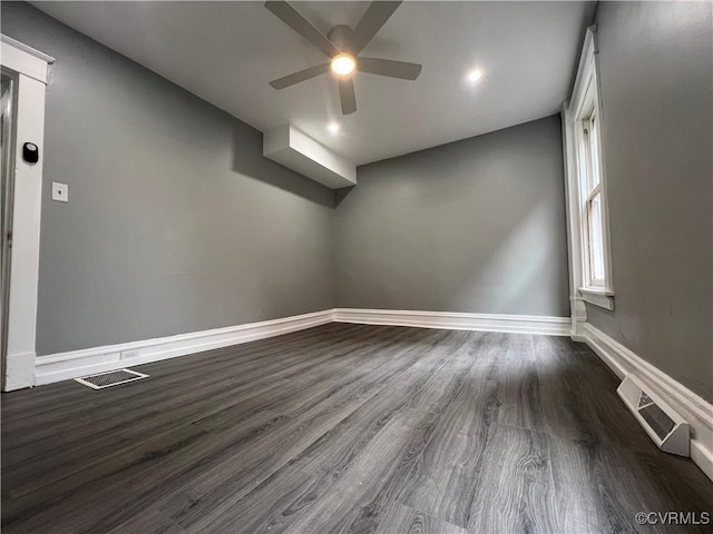 empty room featuring dark wood finished floors, visible vents, baseboards, and a ceiling fan