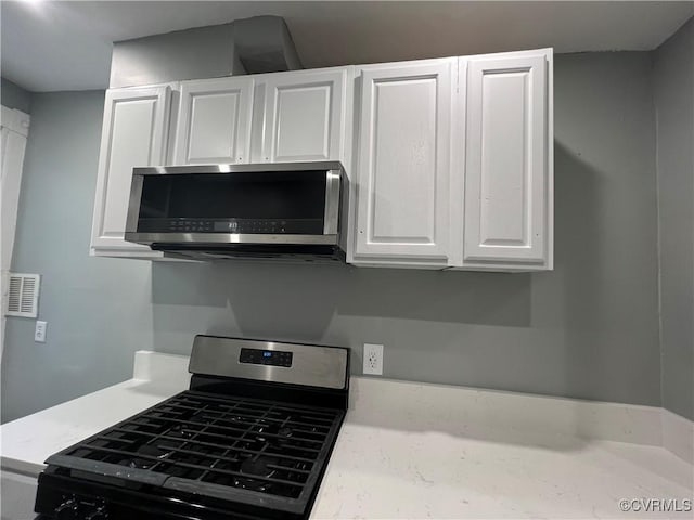 kitchen with light countertops, white cabinets, visible vents, and appliances with stainless steel finishes