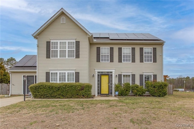 view of front of home featuring solar panels and a front lawn