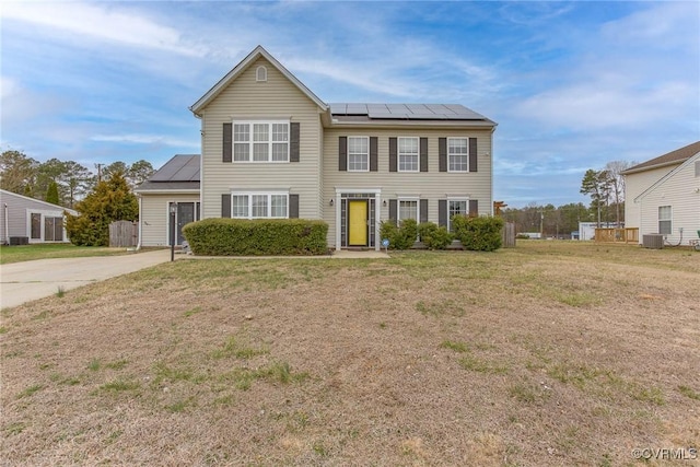 colonial inspired home with cooling unit, solar panels, and a front yard