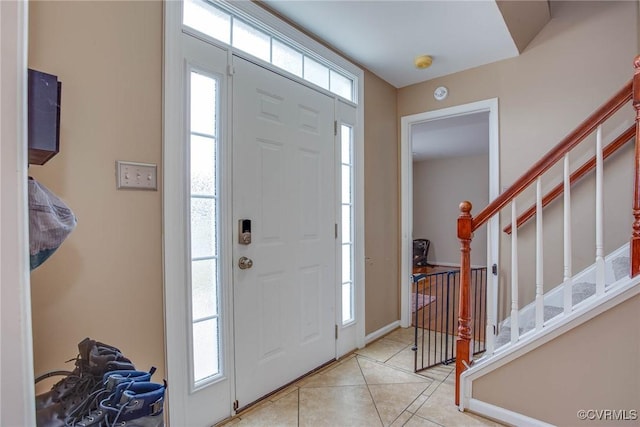 foyer featuring tile patterned flooring, stairs, and baseboards