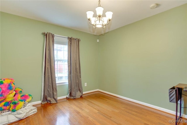 interior space with baseboards, light wood finished floors, and a chandelier