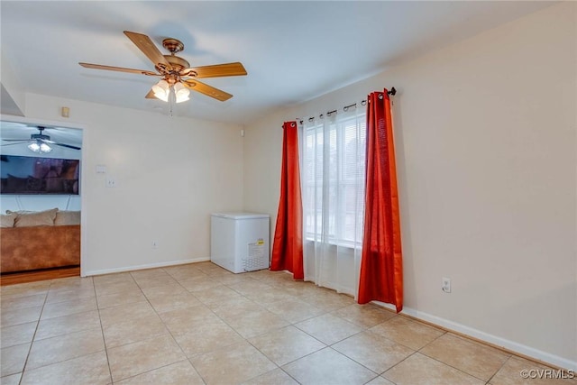 unfurnished room with light tile patterned floors, baseboards, and ceiling fan