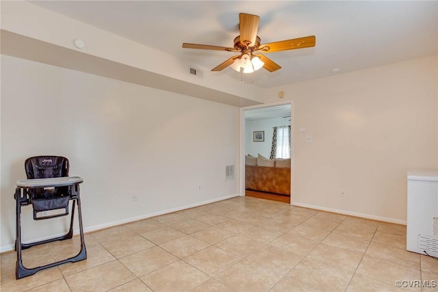 unfurnished room with light tile patterned floors, visible vents, baseboards, and a ceiling fan