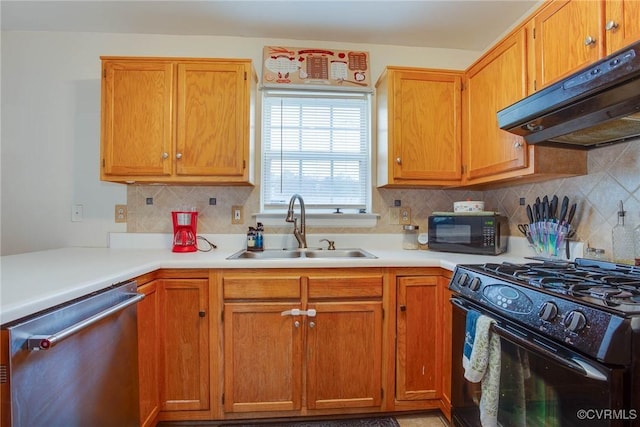 kitchen featuring a sink, black appliances, light countertops, under cabinet range hood, and tasteful backsplash