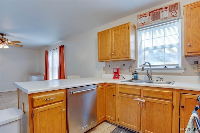 kitchen featuring a peninsula, light tile patterned flooring, a sink, stainless steel dishwasher, and tasteful backsplash