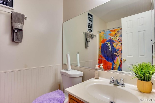 full bath featuring a wainscoted wall and vanity