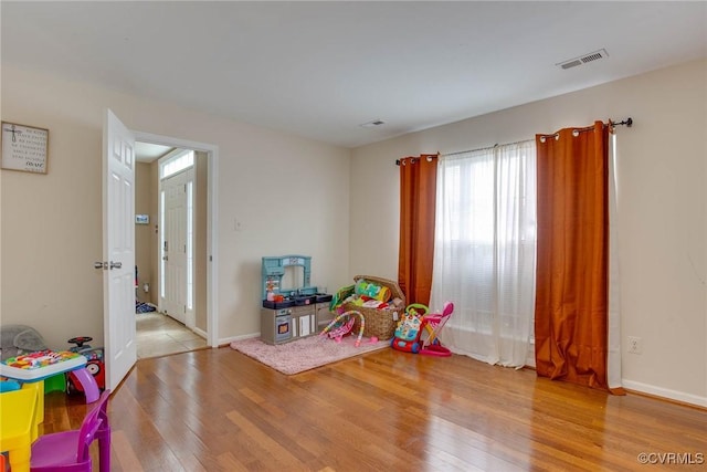 rec room featuring visible vents, baseboards, and wood finished floors