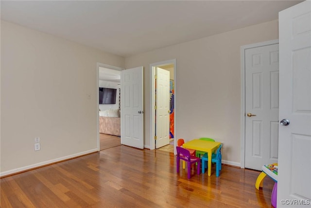 recreation room with baseboards and wood finished floors