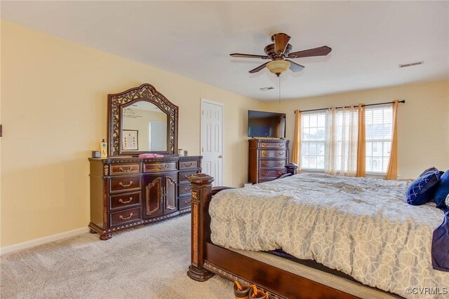 bedroom featuring a ceiling fan, baseboards, visible vents, and light carpet