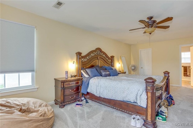 carpeted bedroom featuring visible vents, baseboards, and a ceiling fan