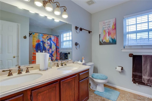 full bathroom featuring double vanity, toilet, visible vents, and a sink