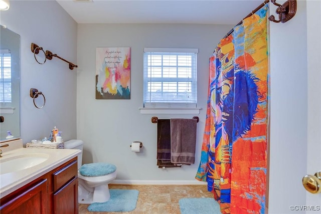 bathroom with a shower with shower curtain, a healthy amount of sunlight, toilet, and vanity