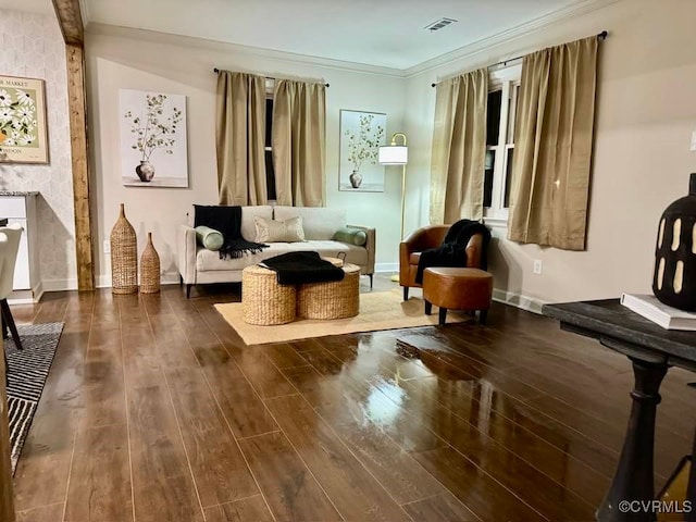 living area featuring crown molding, wood finished floors, baseboards, and visible vents