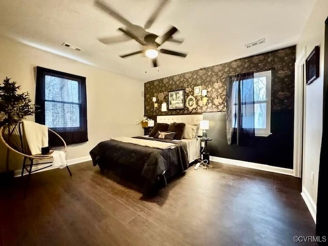 bedroom featuring visible vents, multiple windows, and baseboards