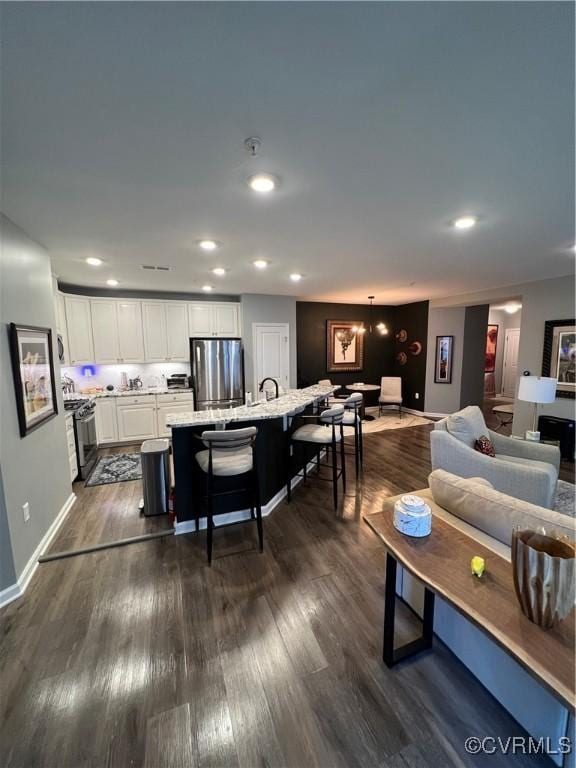 living room with dark wood finished floors, recessed lighting, and baseboards