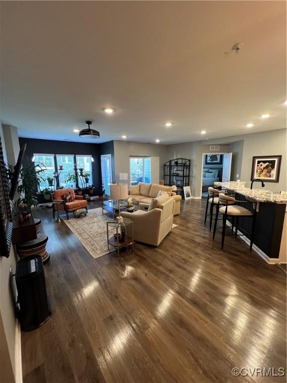 living area featuring dark wood-type flooring, recessed lighting, and baseboards