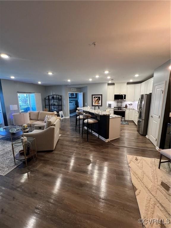 living room with recessed lighting and dark wood-style flooring