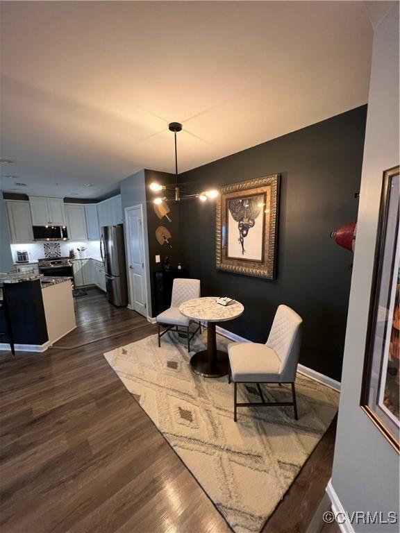 dining space with baseboards and dark wood-style flooring