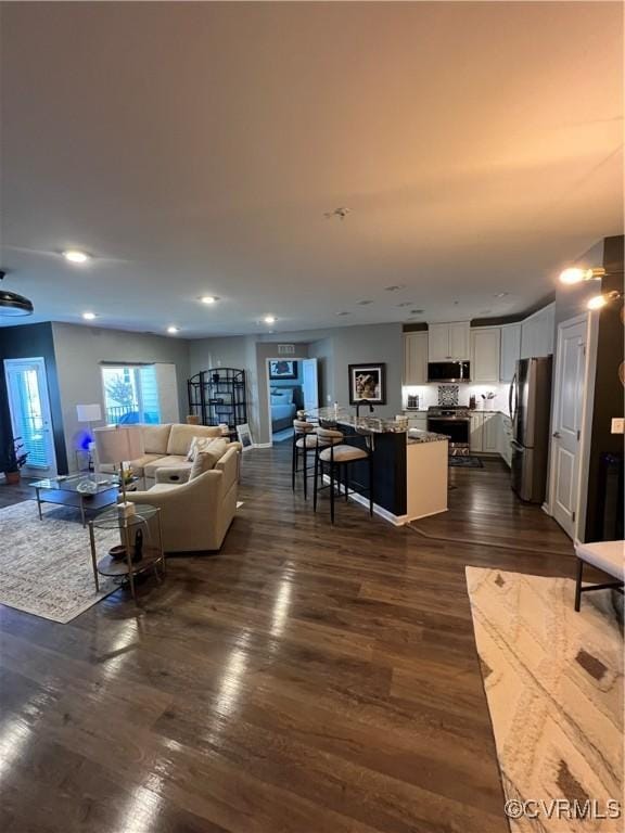 living room featuring recessed lighting and dark wood-style floors