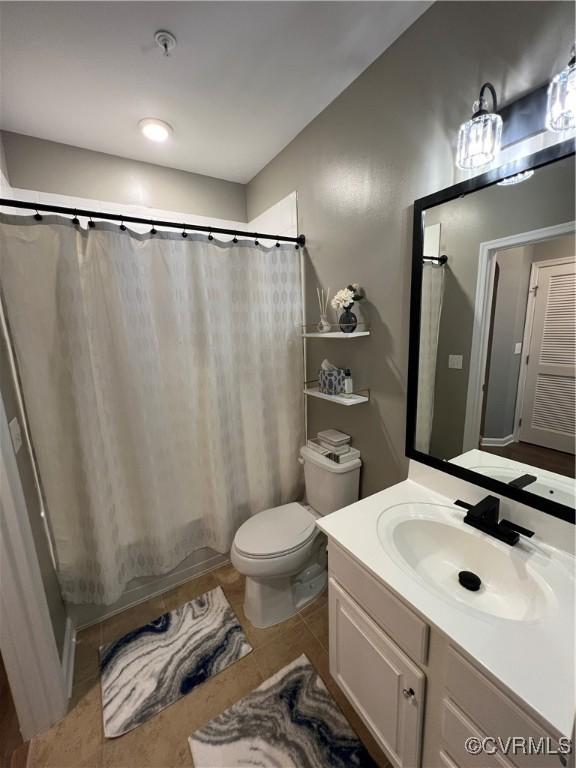 bathroom featuring tile patterned flooring, toilet, vanity, and shower / bath combo