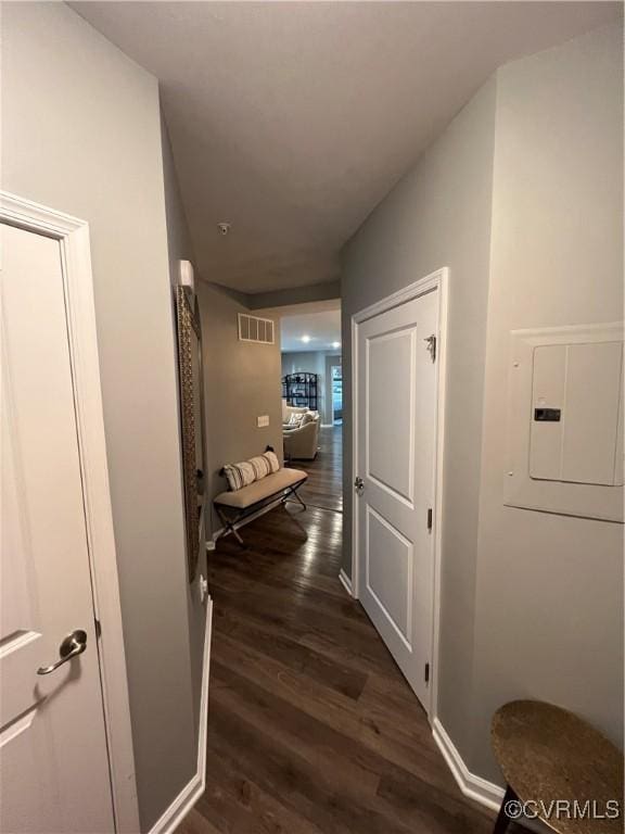 hallway featuring electric panel, visible vents, and dark wood finished floors