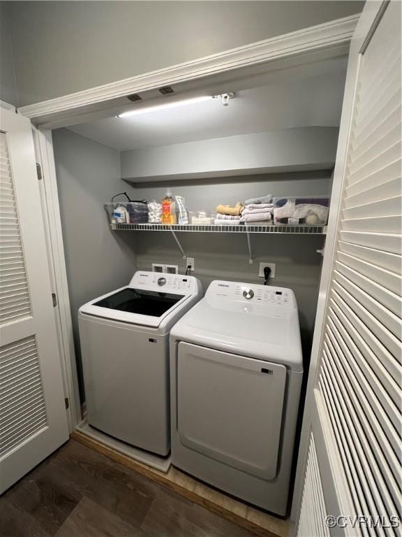 laundry area with wood finished floors, laundry area, and washing machine and clothes dryer