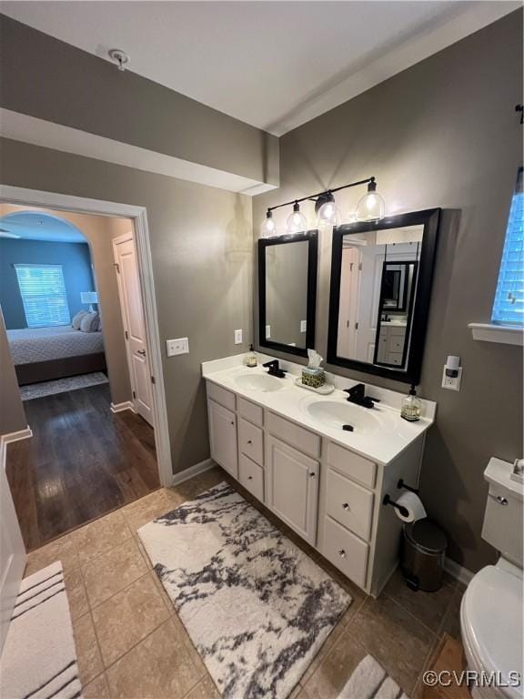 full bathroom featuring double vanity, connected bathroom, tile patterned floors, and a sink