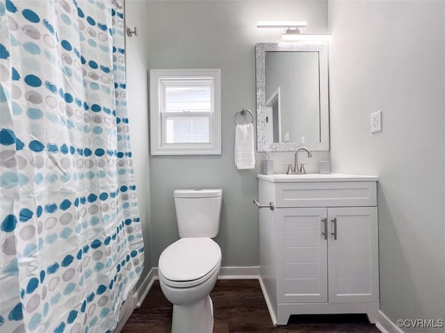 bathroom featuring toilet, curtained shower, wood finished floors, baseboards, and vanity