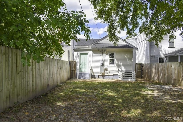 back of property featuring entry steps, a fenced backyard, and a lawn