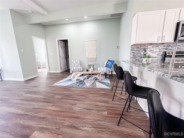 dining room featuring visible vents, baseboards, beamed ceiling, recessed lighting, and wood finished floors