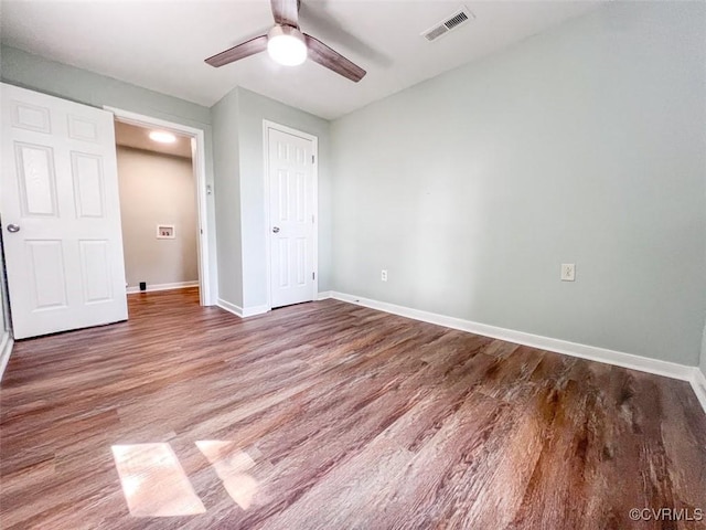 unfurnished bedroom with visible vents, ceiling fan, baseboards, wood finished floors, and a closet