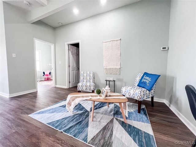 living area featuring beam ceiling, wood finished floors, and baseboards