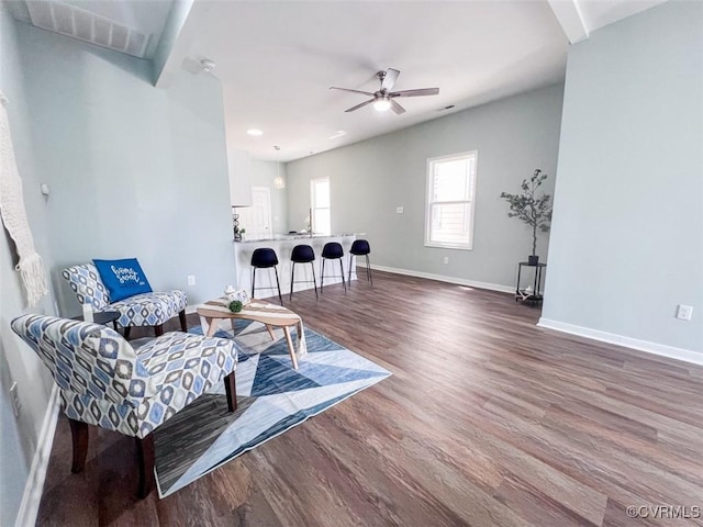 living area featuring a ceiling fan, wood finished floors, and baseboards