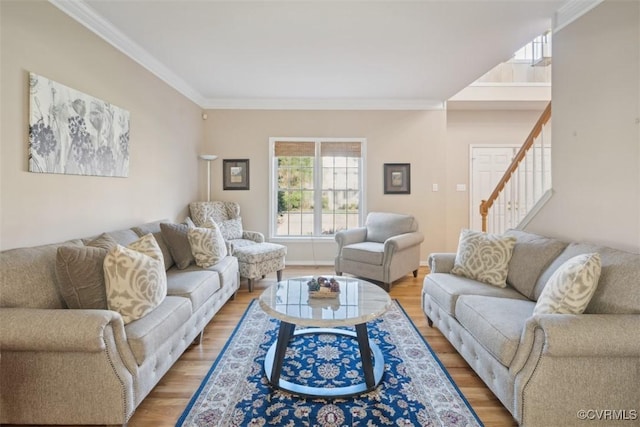 living area with light wood-style flooring, ornamental molding, and stairway