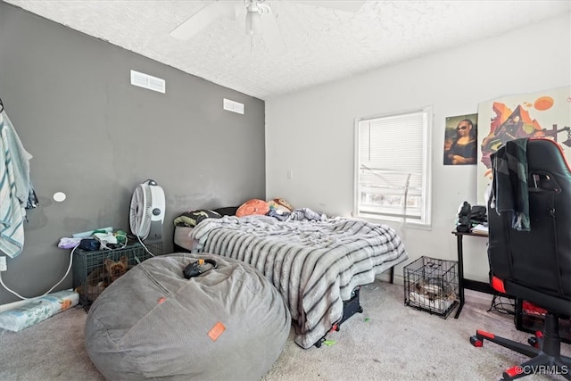 bedroom featuring visible vents, carpet floors, a textured ceiling, and ceiling fan