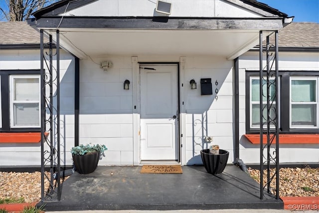 property entrance with a shingled roof