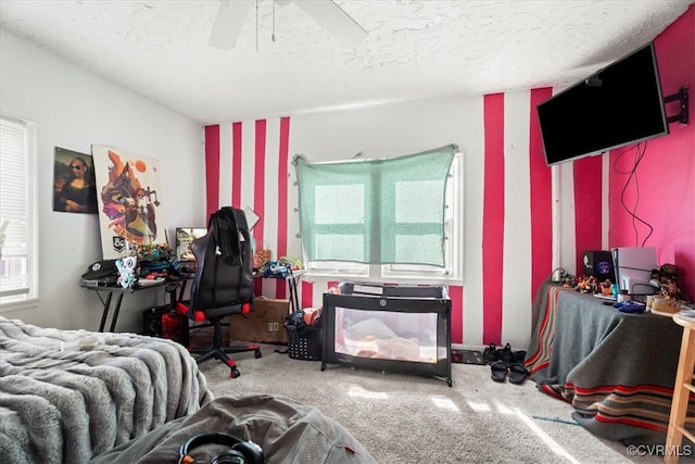 bedroom featuring carpet flooring, a ceiling fan, and a textured ceiling