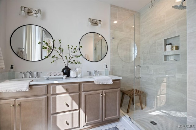 bathroom with double vanity, a shower stall, and a sink