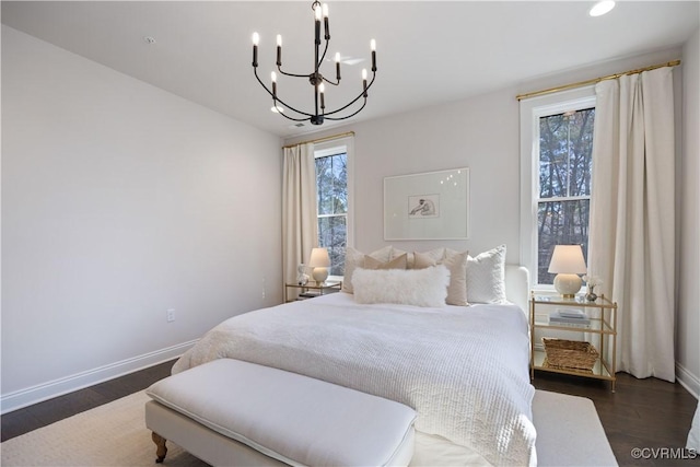 bedroom featuring dark wood-style floors, recessed lighting, baseboards, and an inviting chandelier