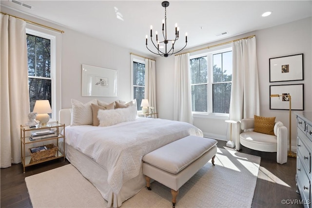 bedroom with visible vents, baseboards, recessed lighting, an inviting chandelier, and dark wood-style floors