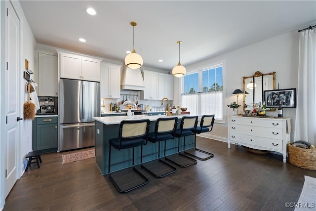 kitchen featuring tasteful backsplash, dark wood finished floors, light countertops, and freestanding refrigerator