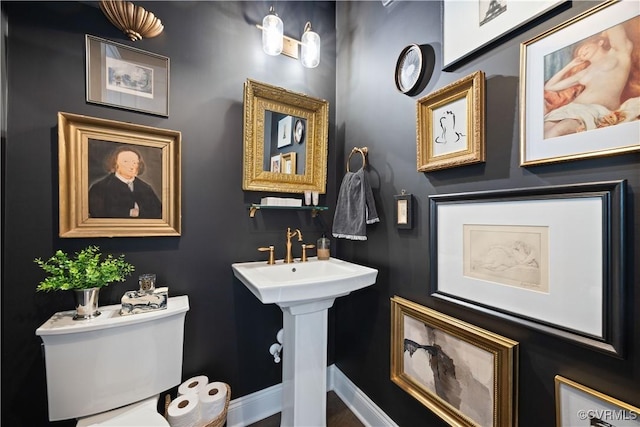 bathroom featuring toilet and baseboards