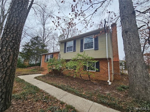 view of front of home with brick siding and a chimney