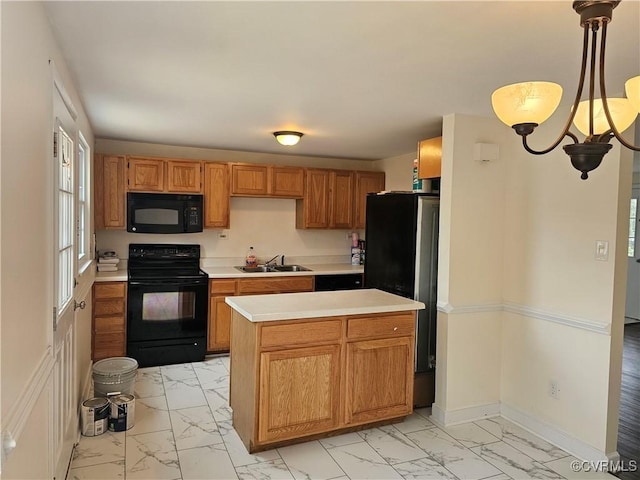 kitchen featuring marble finish floor, black appliances, light countertops, and a sink