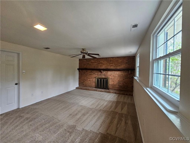 unfurnished living room featuring visible vents, a fireplace, a ceiling fan, and carpet